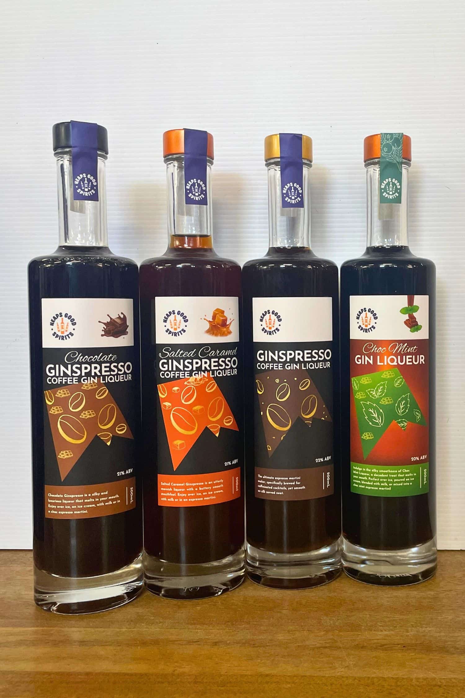 Heaps Good Spirits Ginspresso range featuring Chocolate, Salted Caramel, Original Ginspresso and Choc Mint Gin Liqueur bottles on wooden surface