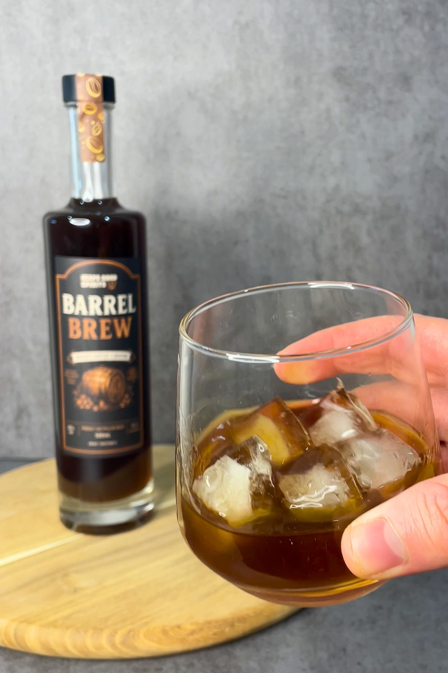 Barrel Brew whisky coffee liqueur bottle beside a glass poured over ice, showcasing its rich dark colour and smooth serving suggestion.