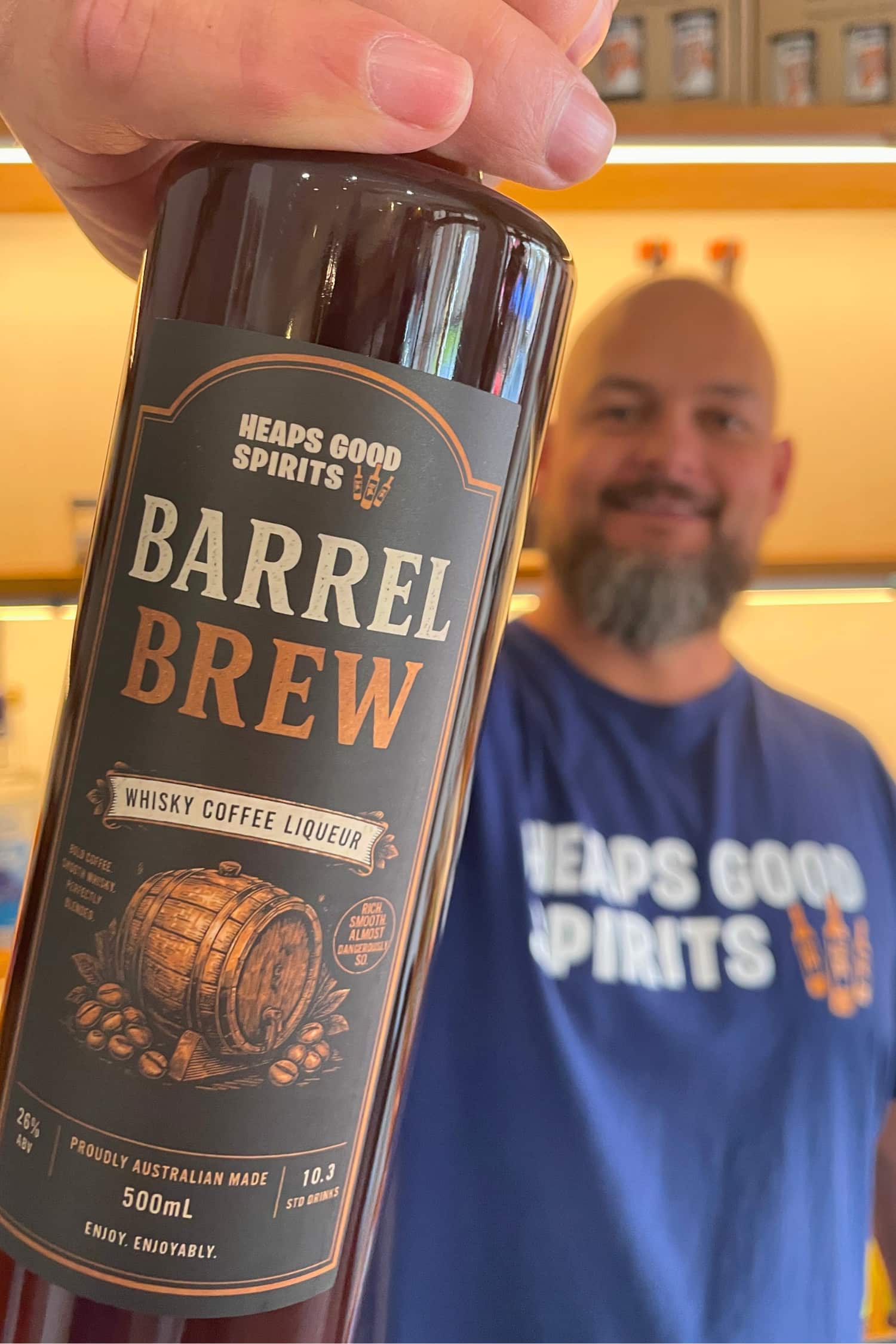 Bottle of Barrel Brew whisky coffee liqueur being held up close to the camera by Heaps Good Spirits founder Greg.