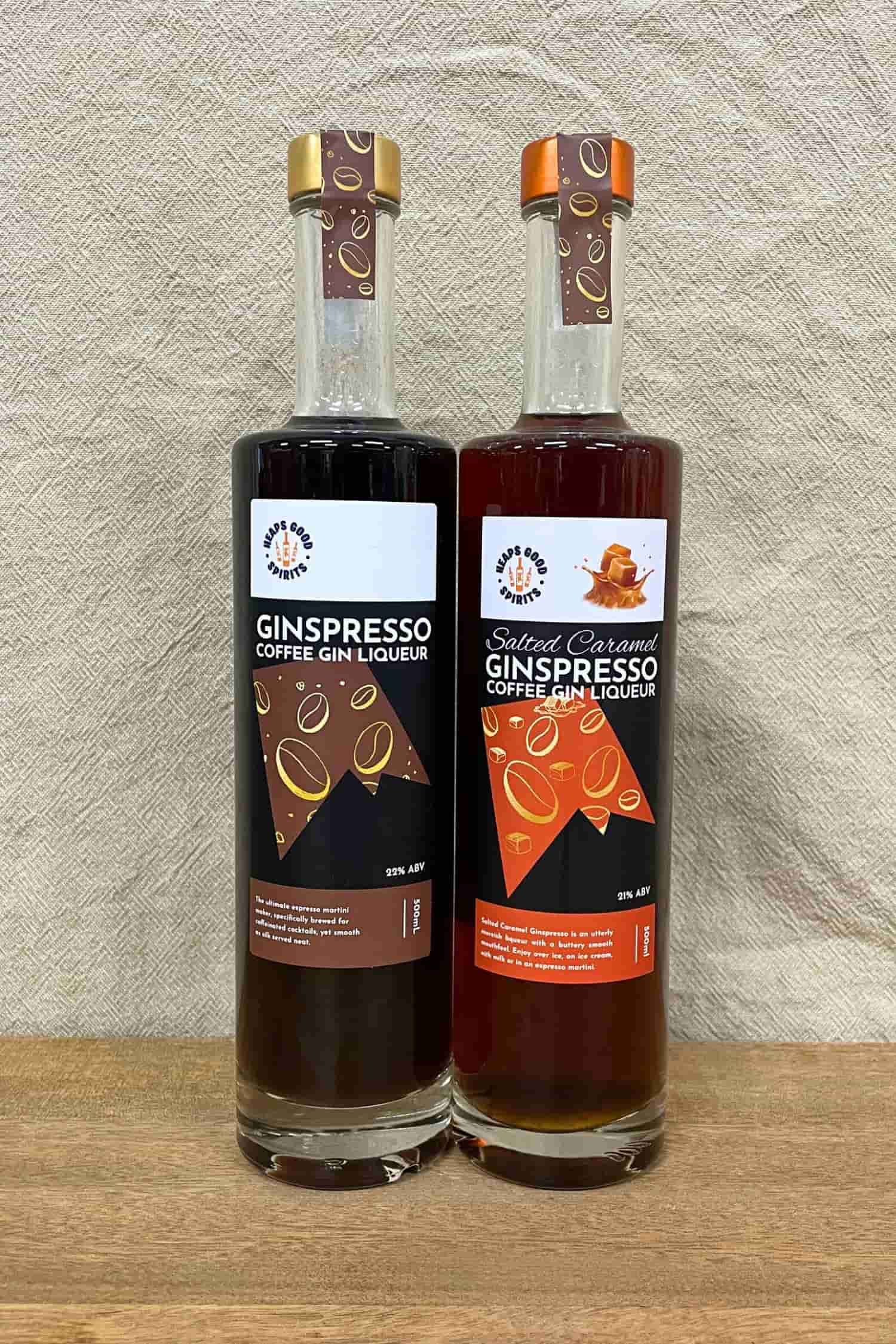 Ginspresso and Salted Caramel Ginspresso coffee gin liqueur bottles side by side on wooden surface.