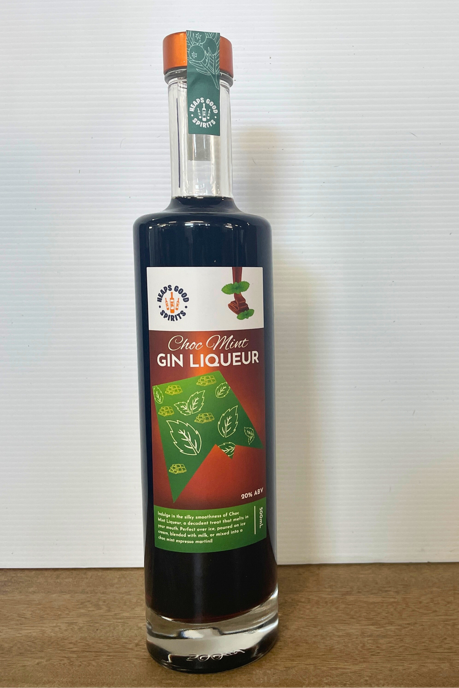 Bottle of Choc Mint Gin Liqueur on a wooden surface with a white background