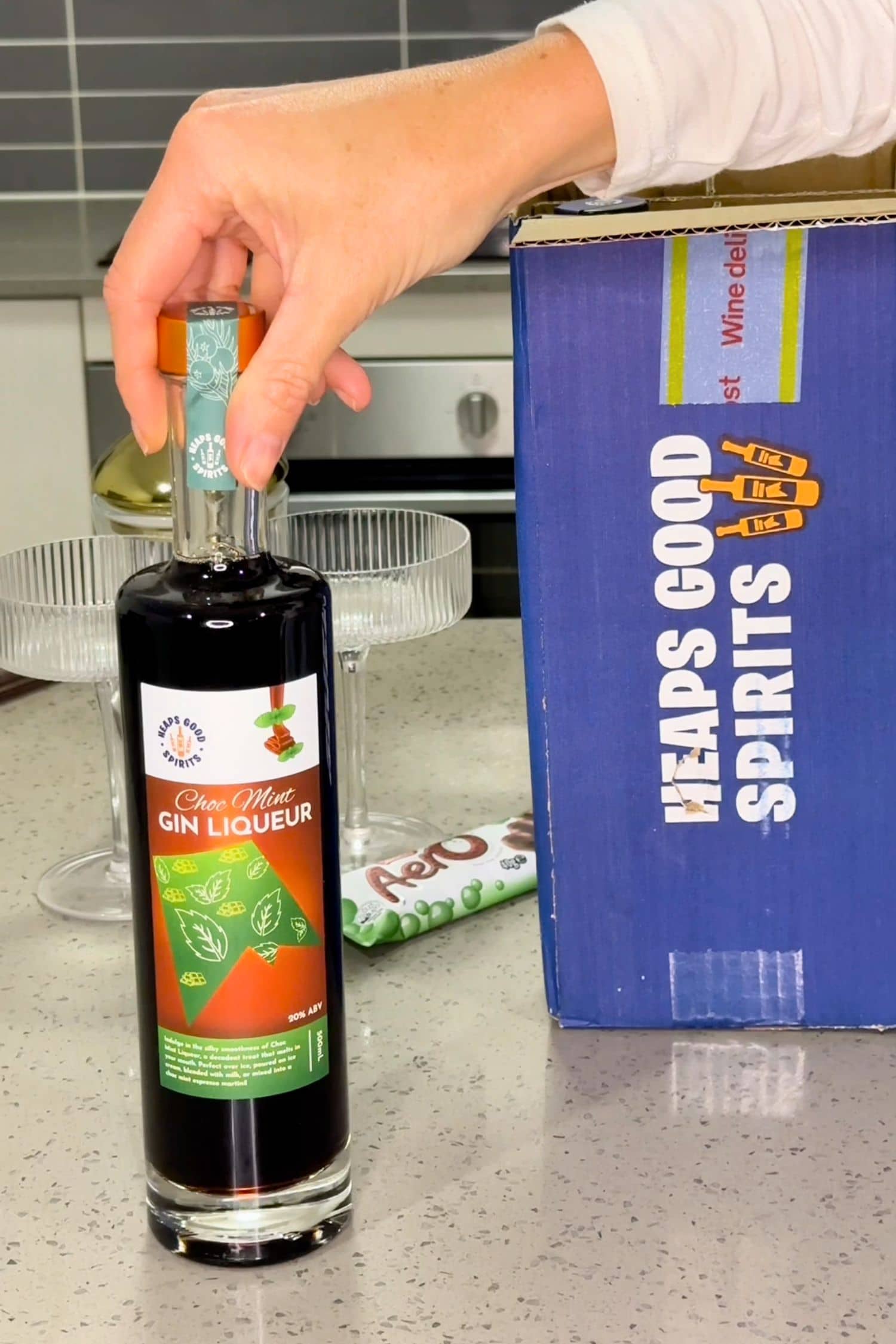 Choc Mint Gin Liqueur bottle next to Heaps Good Spirits shipping box on kitchen counter