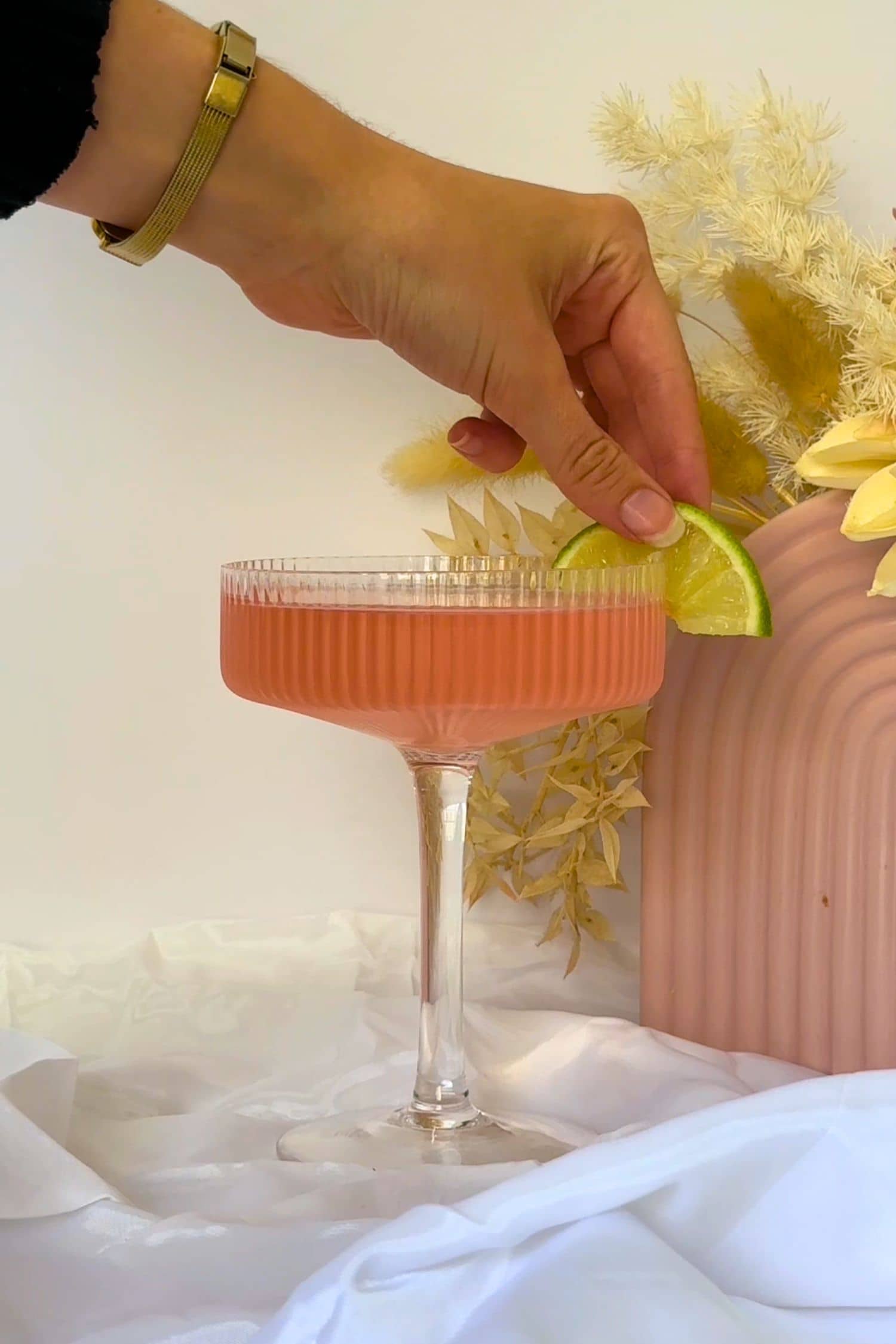 Australian Native Pink Gin cocktail serving being garnished with lime slice.