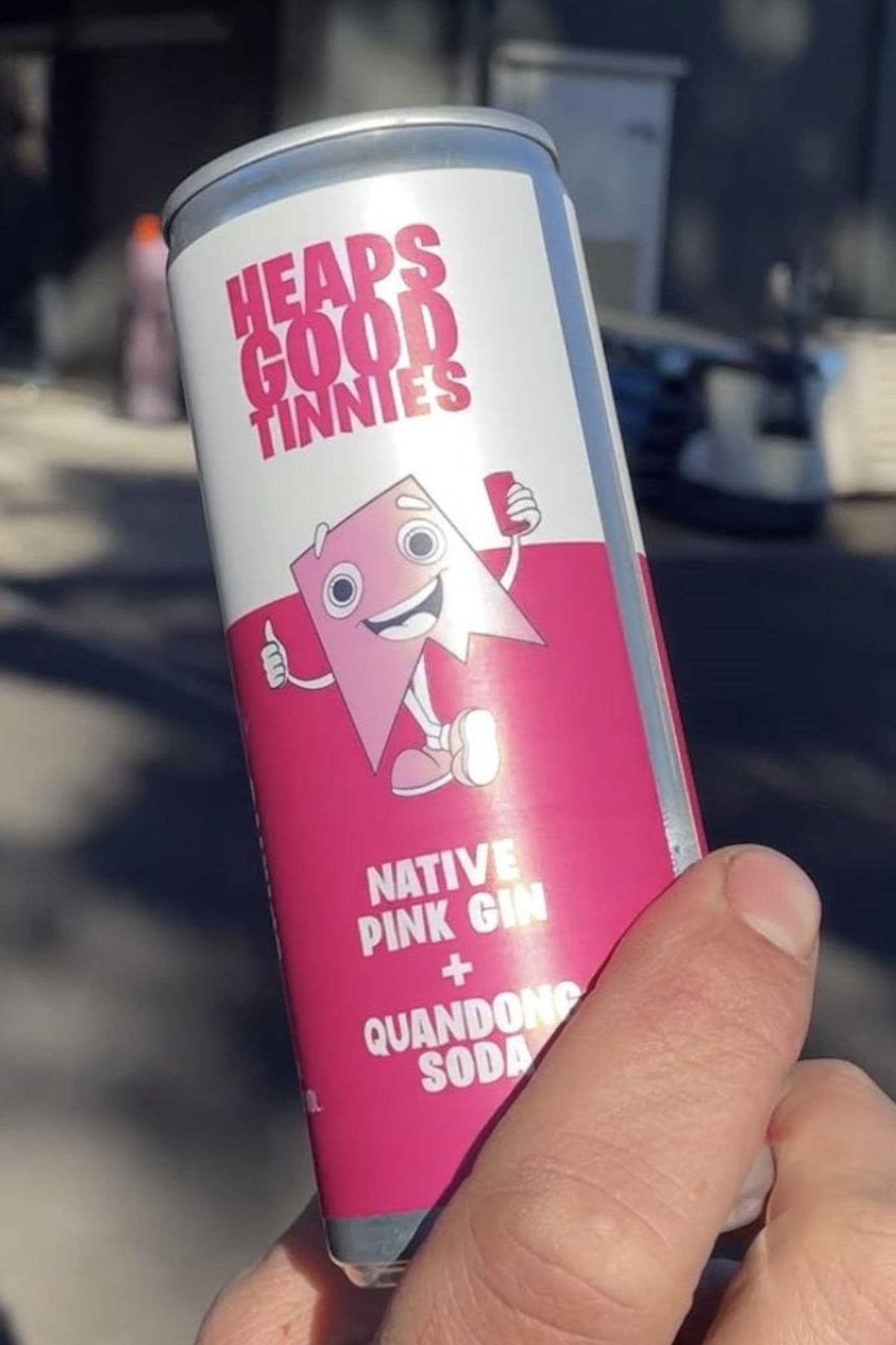 Ready to drink native pink gin and quandong soda premix can close up held in hand.