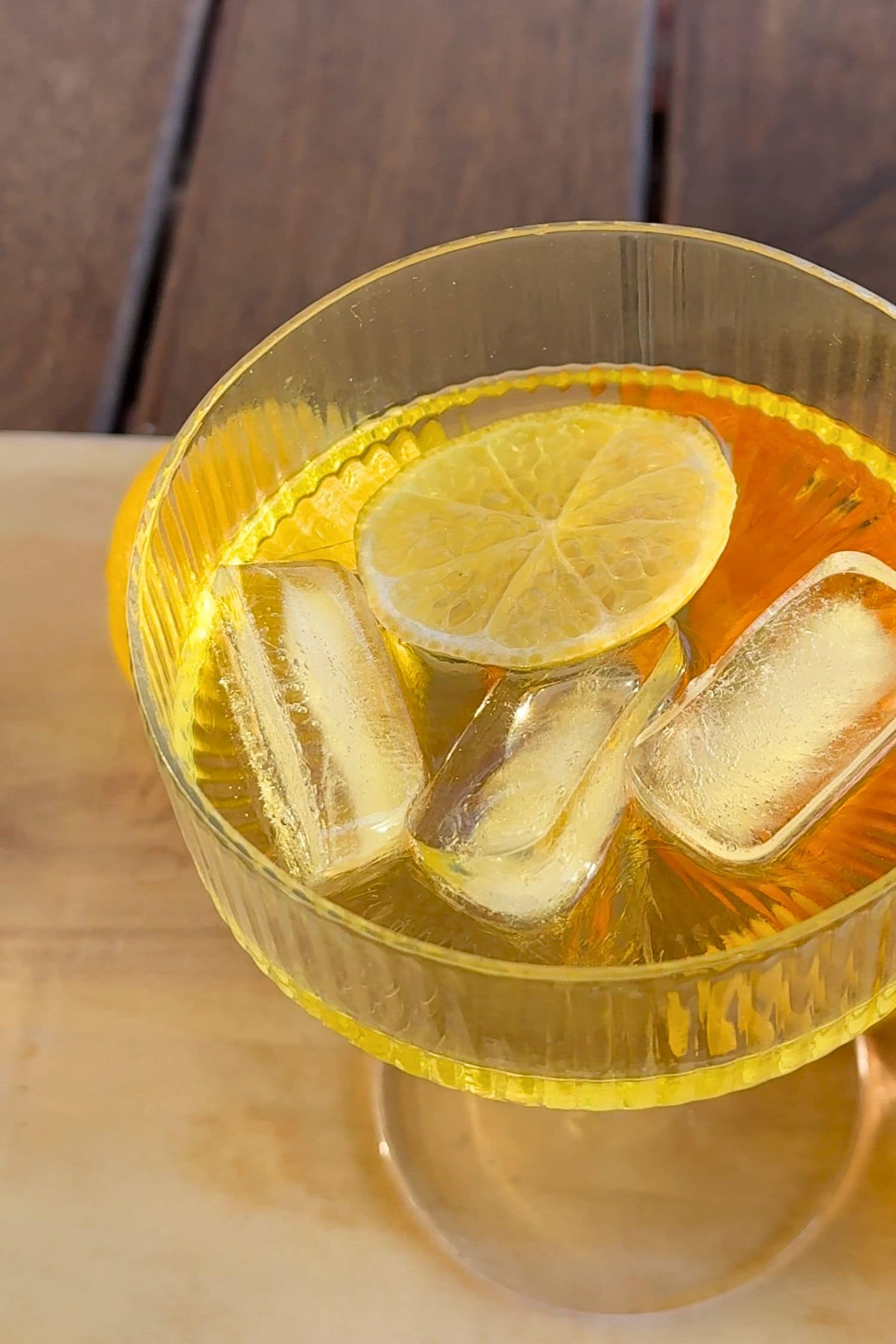 Voddi’s Tropical Punch Flavoured Vodka served over ice with lemon slice in textured glass