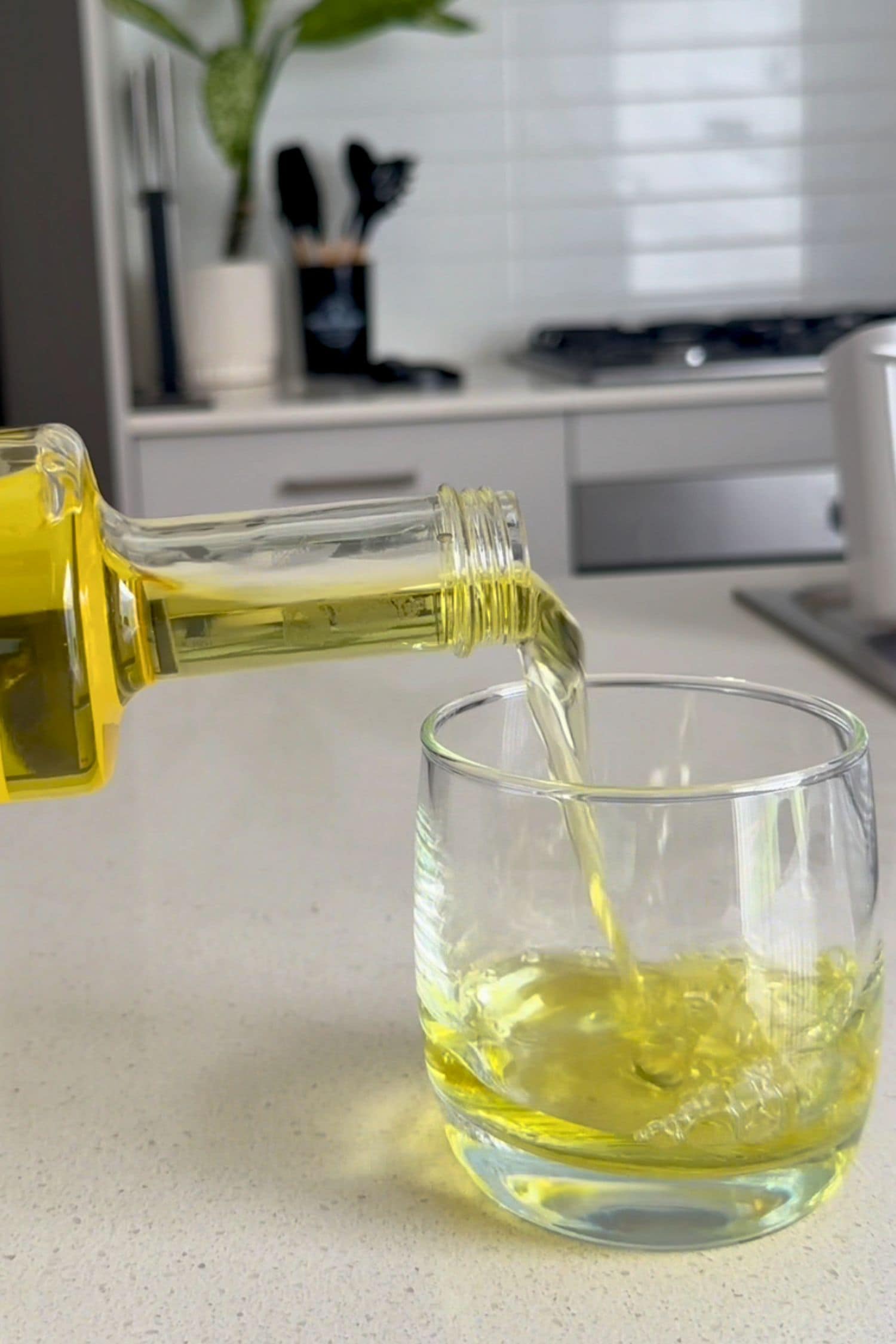 Voddi’s Tropical Punch Flavoured Vodka being poured into a glass on kitchen bench