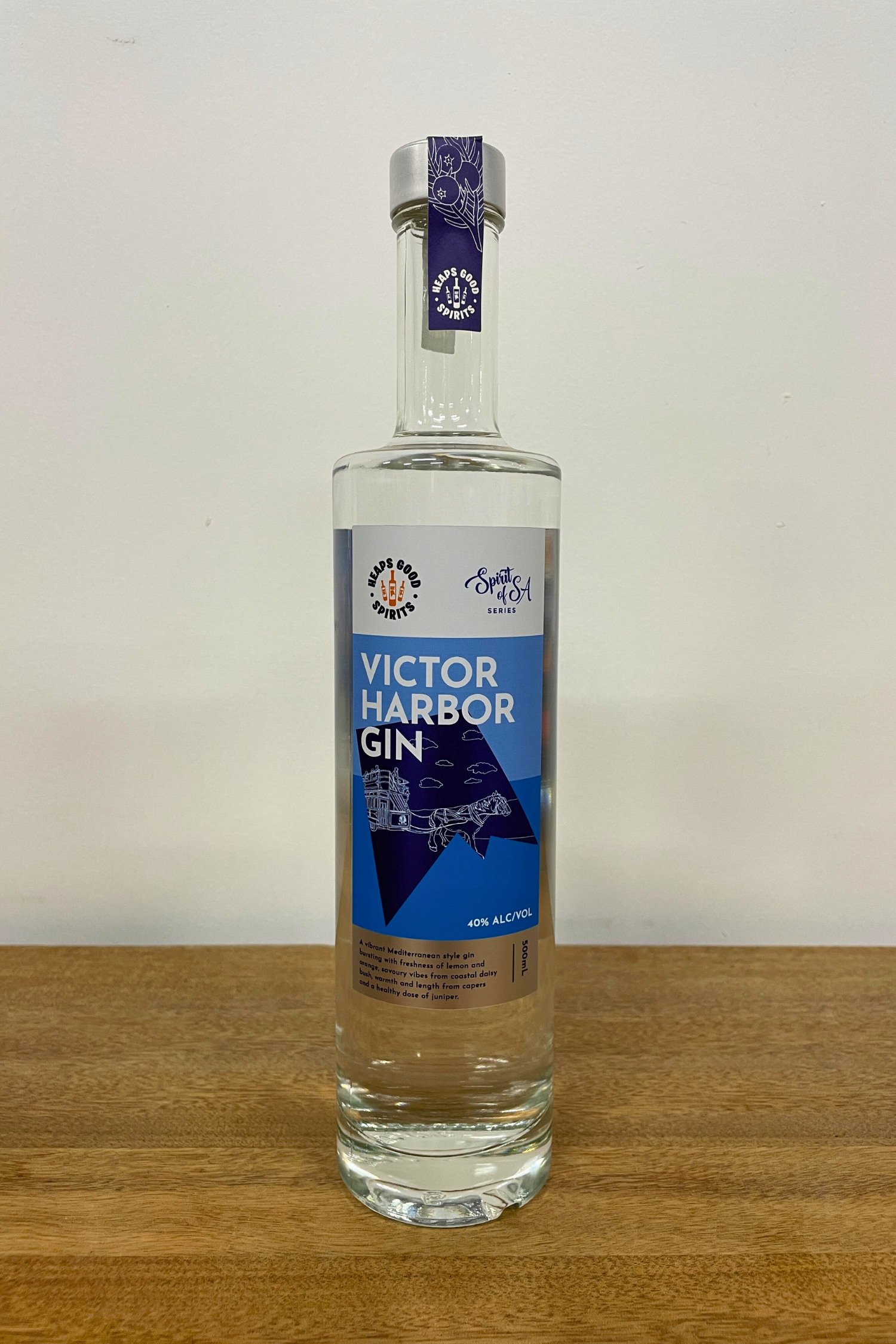 Bottle of Victor Harbor Gin on a wooden surface with a white background