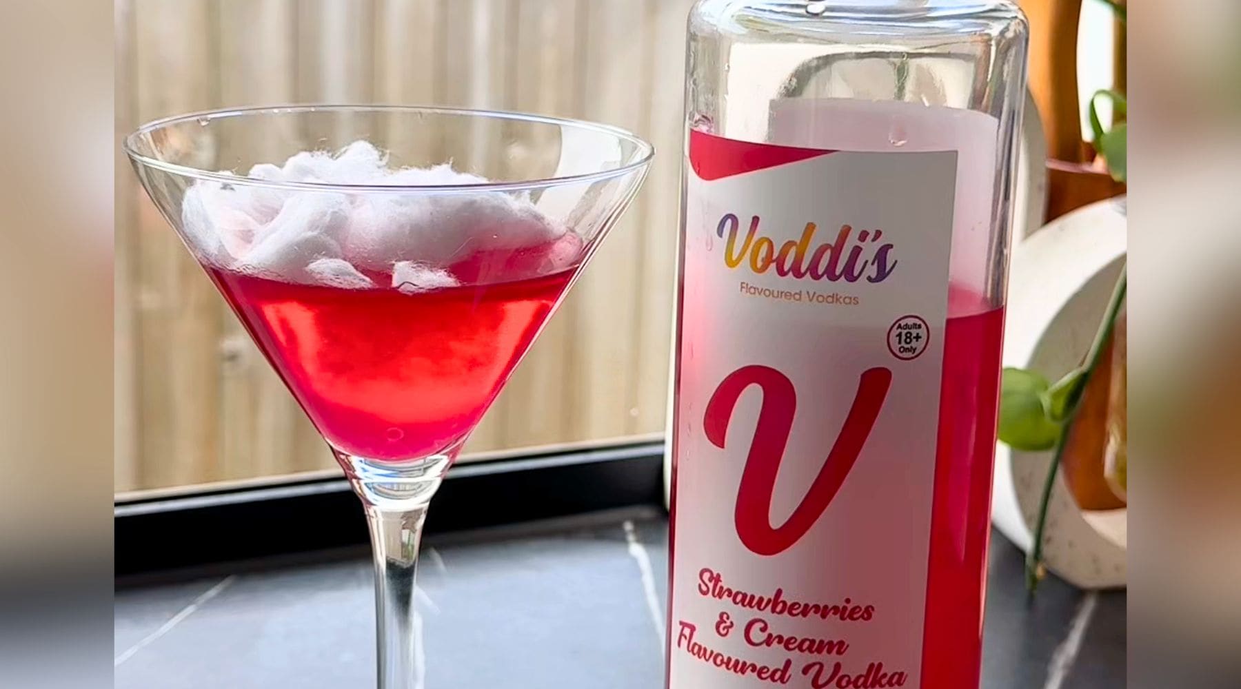 Fairy Floss Strawberry Vodka cocktail, with bottle of Voddi's Strawberries & Cream Vodka.