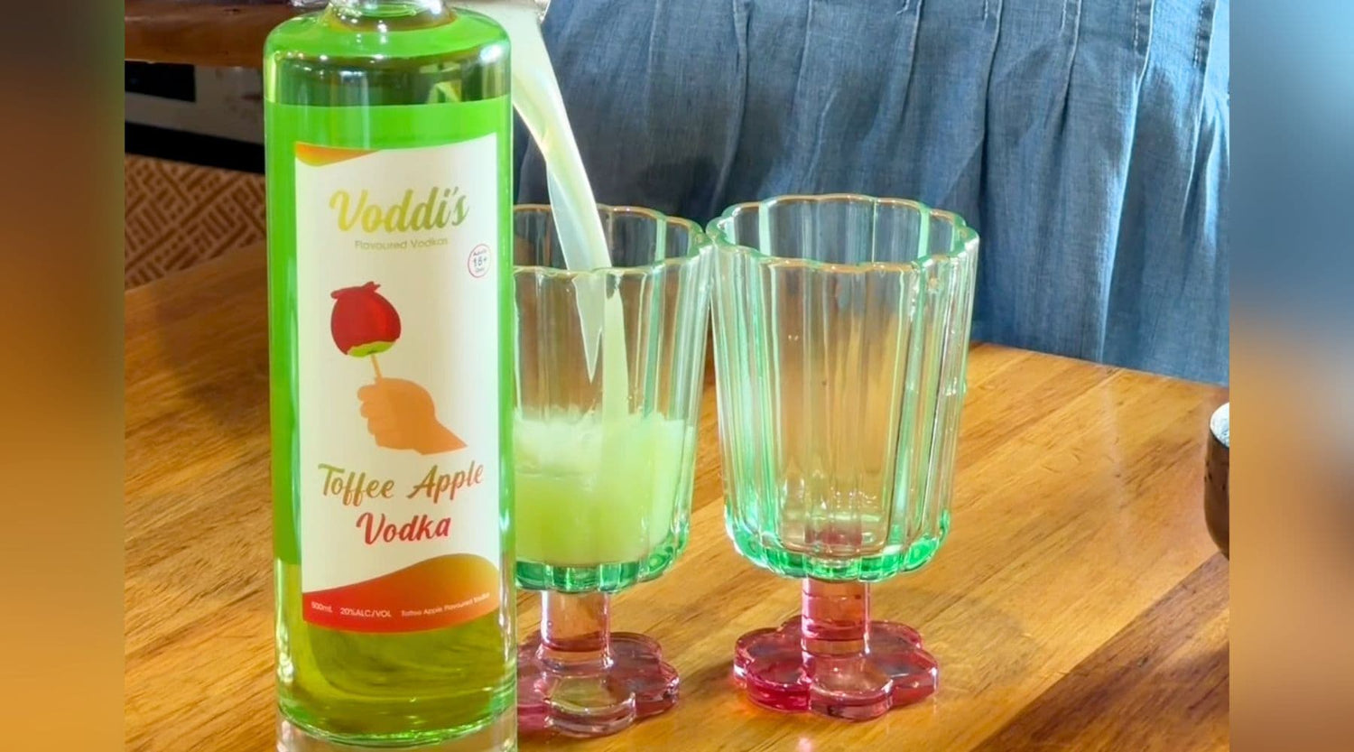 Apple Vodka & Juice cocktail served next to bottle of Toffee Apple Vodka by Heaps Good Spirits.