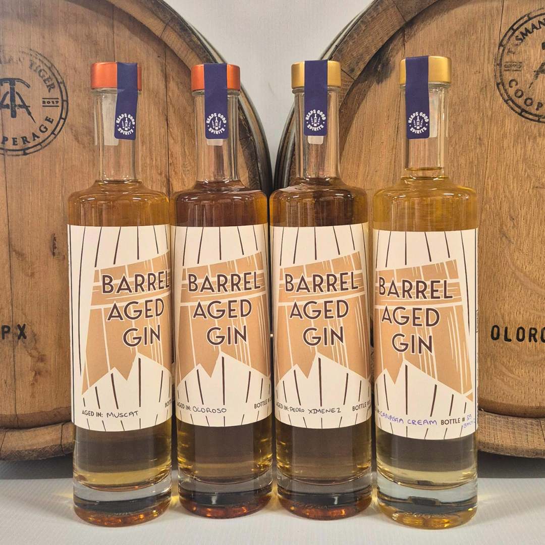 Barrel Aged Gin range set up in front of casks.