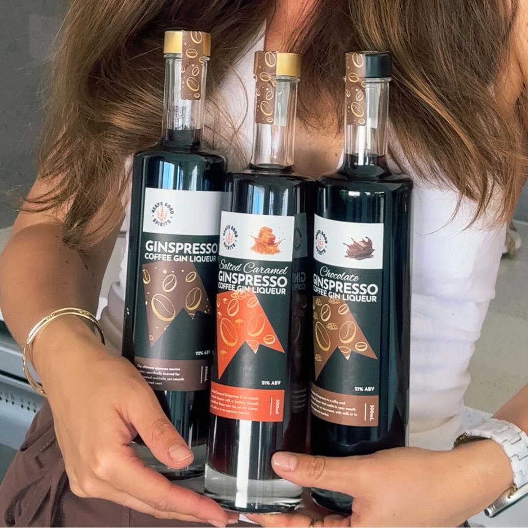 The full Ginspresso coffee gin liqueur range being held in two hands by a customer.