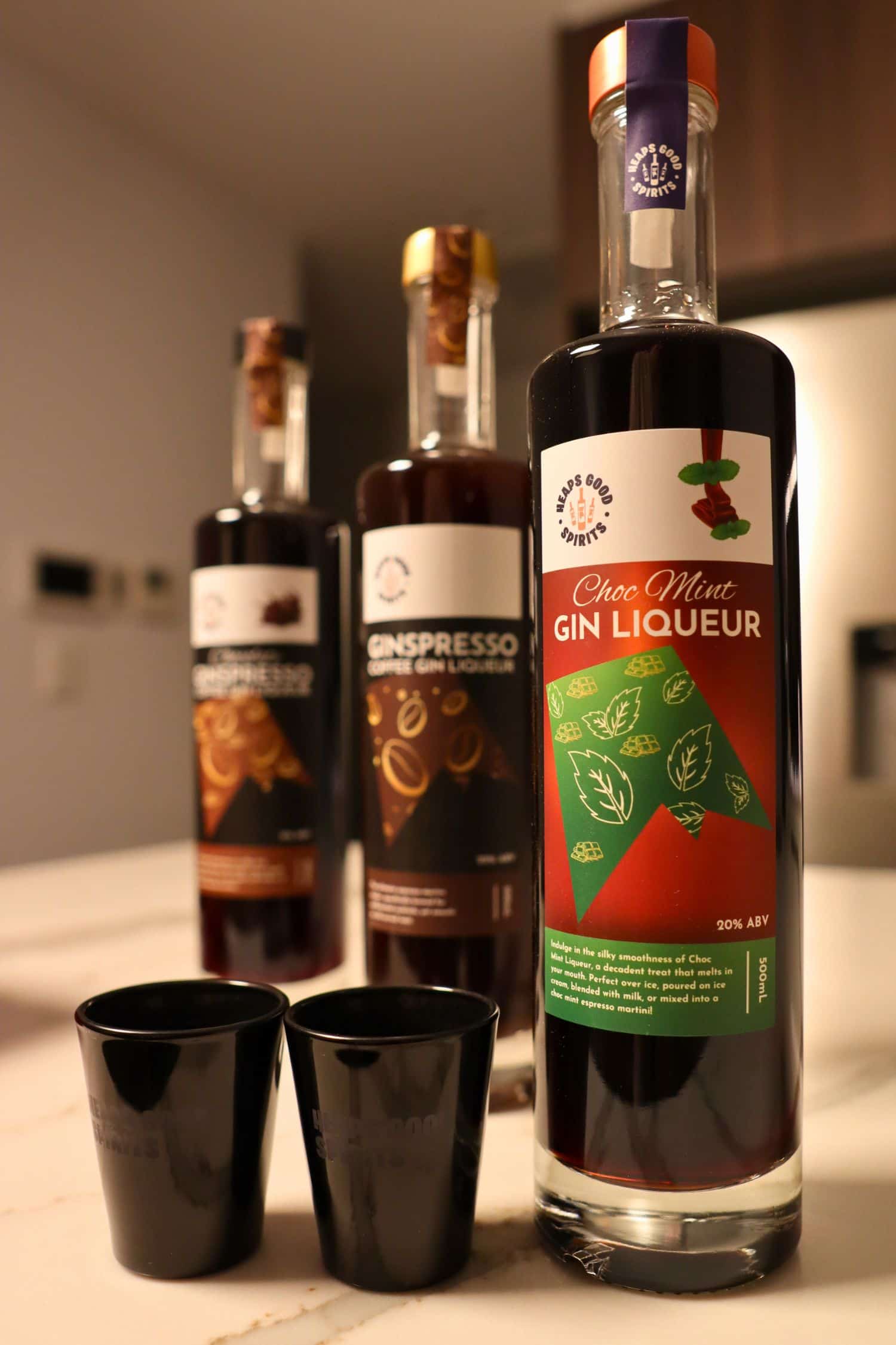 Choc Mint Gin Liqueur bottle with Ginspresso coffee gin liqueur bottles and black shot glasses