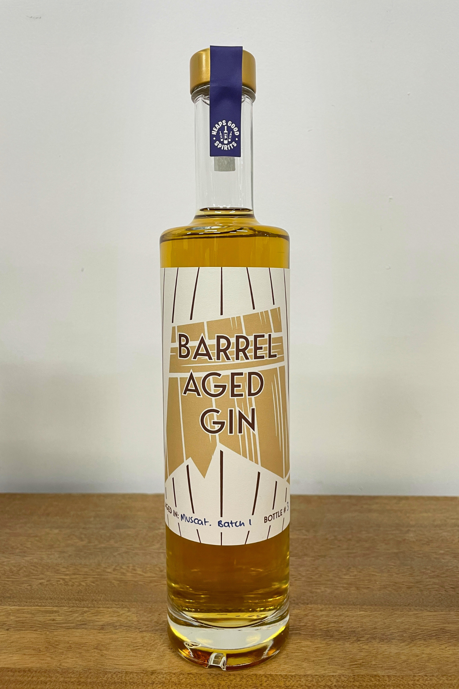 Bottle of Barrel Aged Gin on a wooden surface with a white background