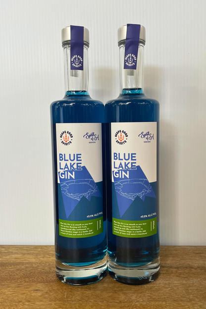 Two bottles of Blue Lake Gin on a wooden surface with a white background