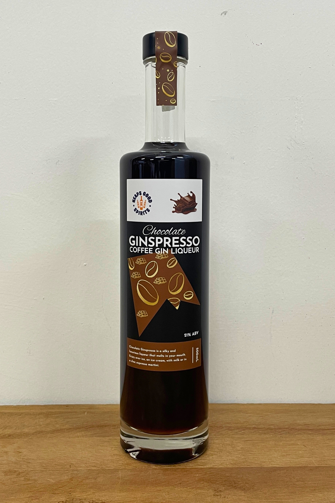 Bottle of Chocolate Ginspresso Coffee Gin Liqueur on a wooden surface with a white background