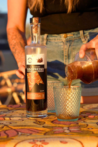 Chocolate Ginspresso coffee gin liqueur poured into cocktail glass outdoors.