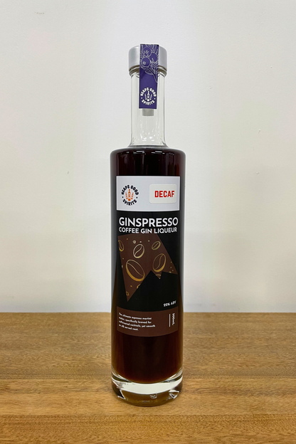 Bottle of Decaf Ginspresso Coffee Gin Liqueur on a wooden surface with a white background