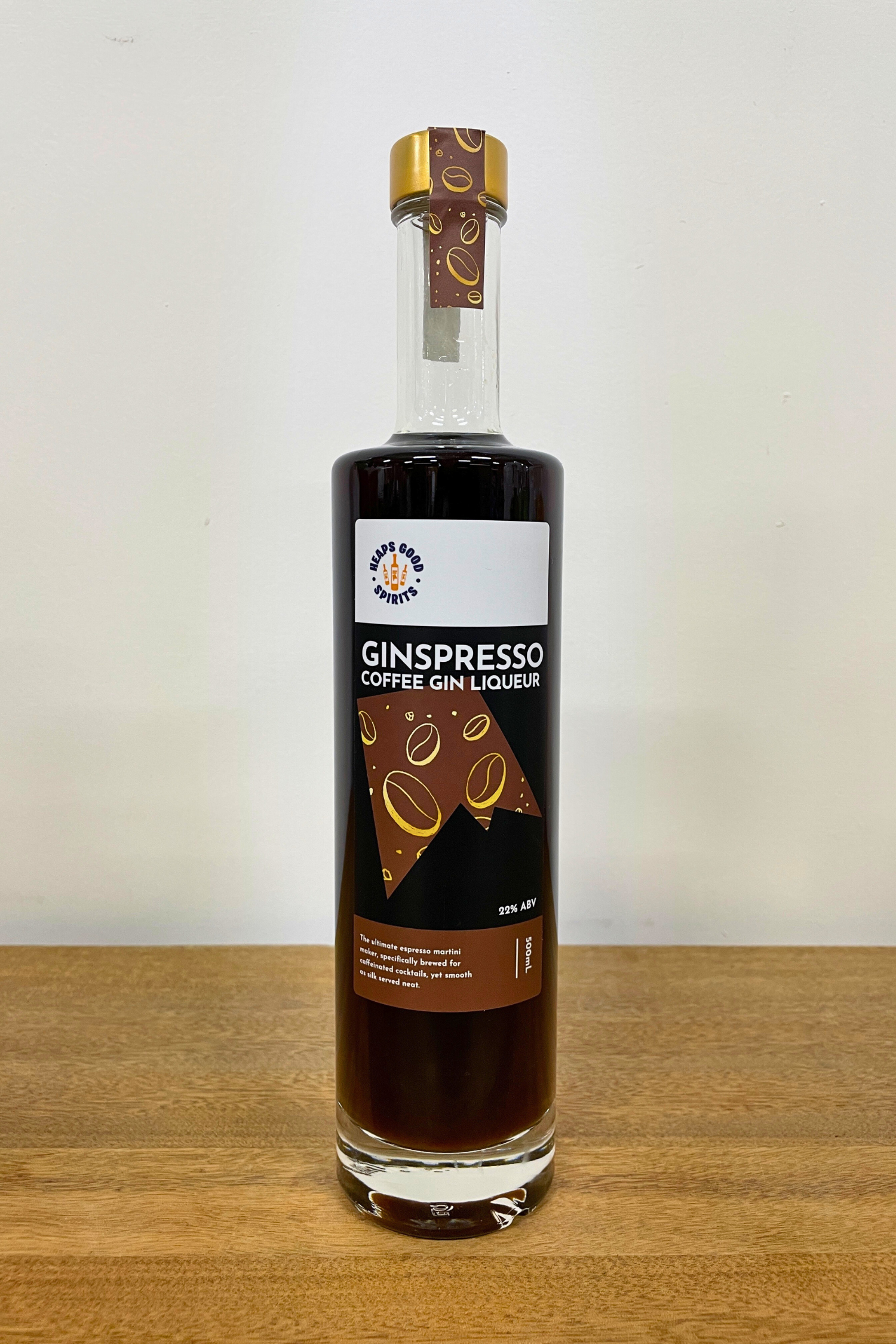 Bottle of Ginspresso Coffee Gin Liqueur on a wooden surface with a white background