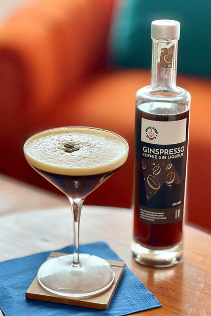 Ginspresso coffee gin liqueur bottle beside freshly made espresso martini.