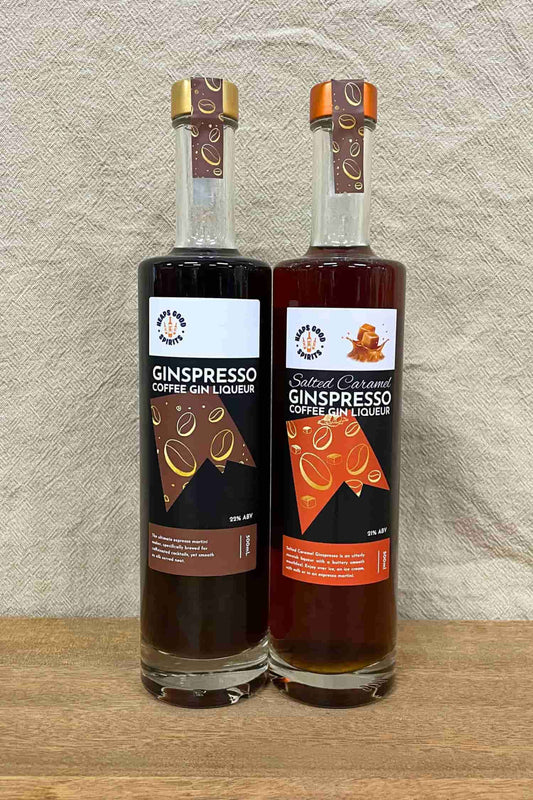 Ginspresso and Salted Caramel Ginspresso coffee gin liqueur bottles side by side on wooden surface.