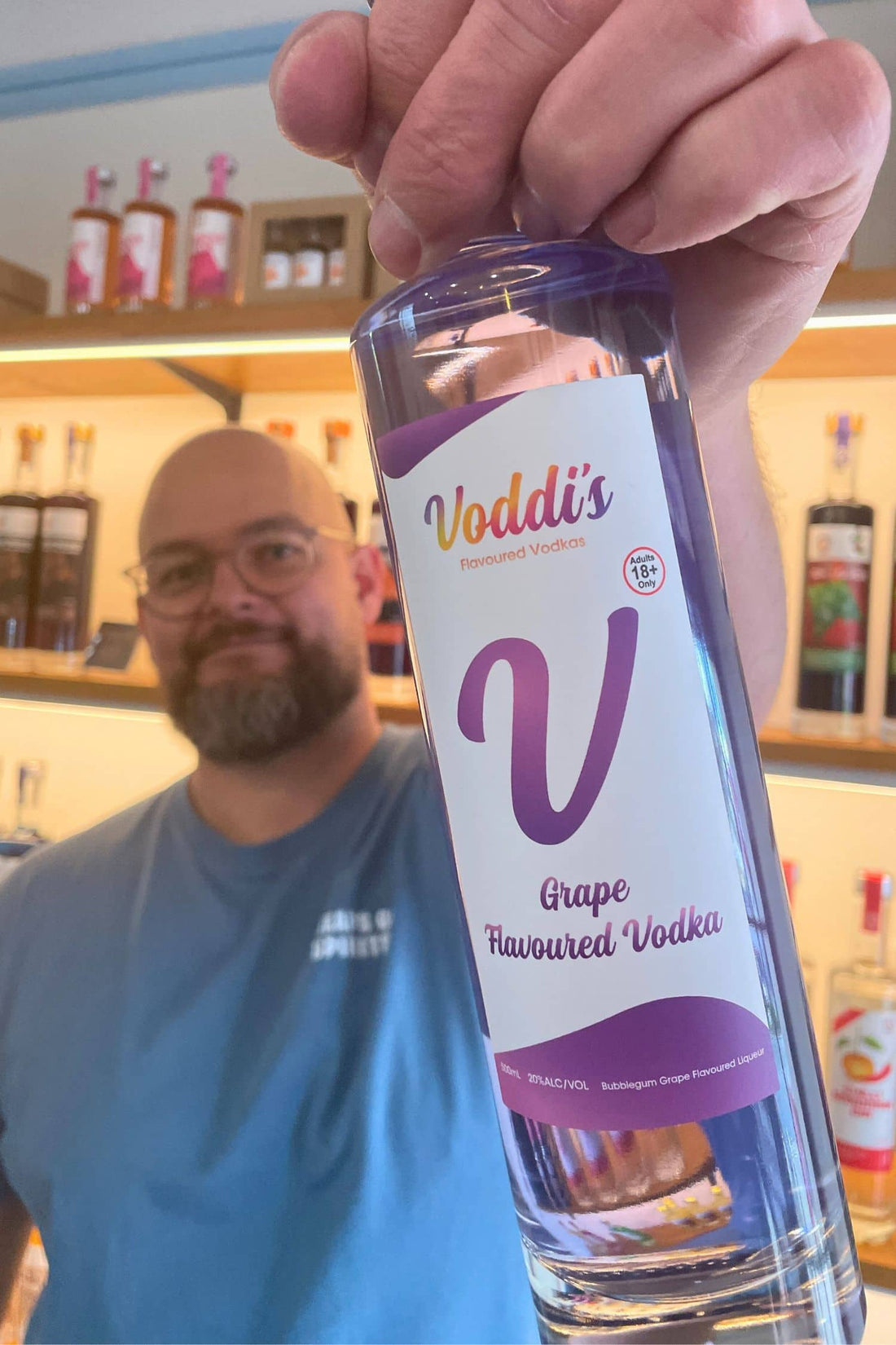 Founder holding Voddi’s Bubblegum Grape Flavoured Vodka bottle inside Heaps Good Spirits tasting room