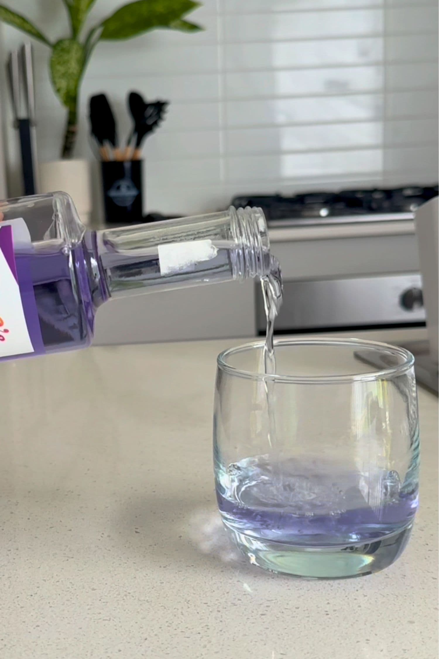 Voddi’s Bubblegum Grape Flavoured Vodka being poured into a glass in modern kitchen setting