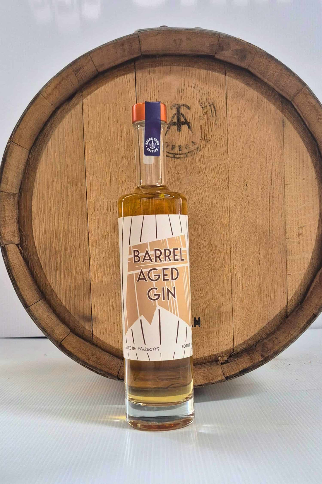 Barrel Aged Gin bottle in front of Muscat barrel that it was aged in