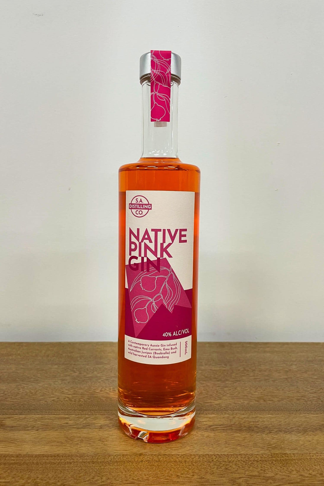 Heaps Good Native Pink Gin 500ml bottle on wooden surface against white background