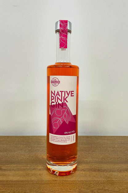 Heaps Good Native Pink Gin 500ml bottle on wooden surface against white background