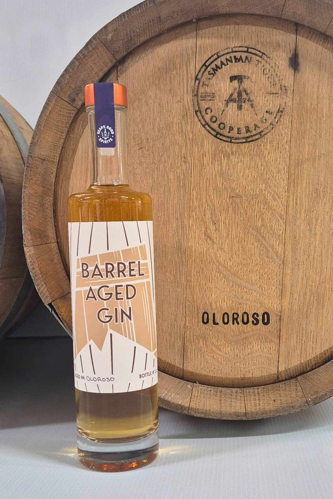 Barrel Aged Gin bottle in front of Oloroso barrel that it was aged in
