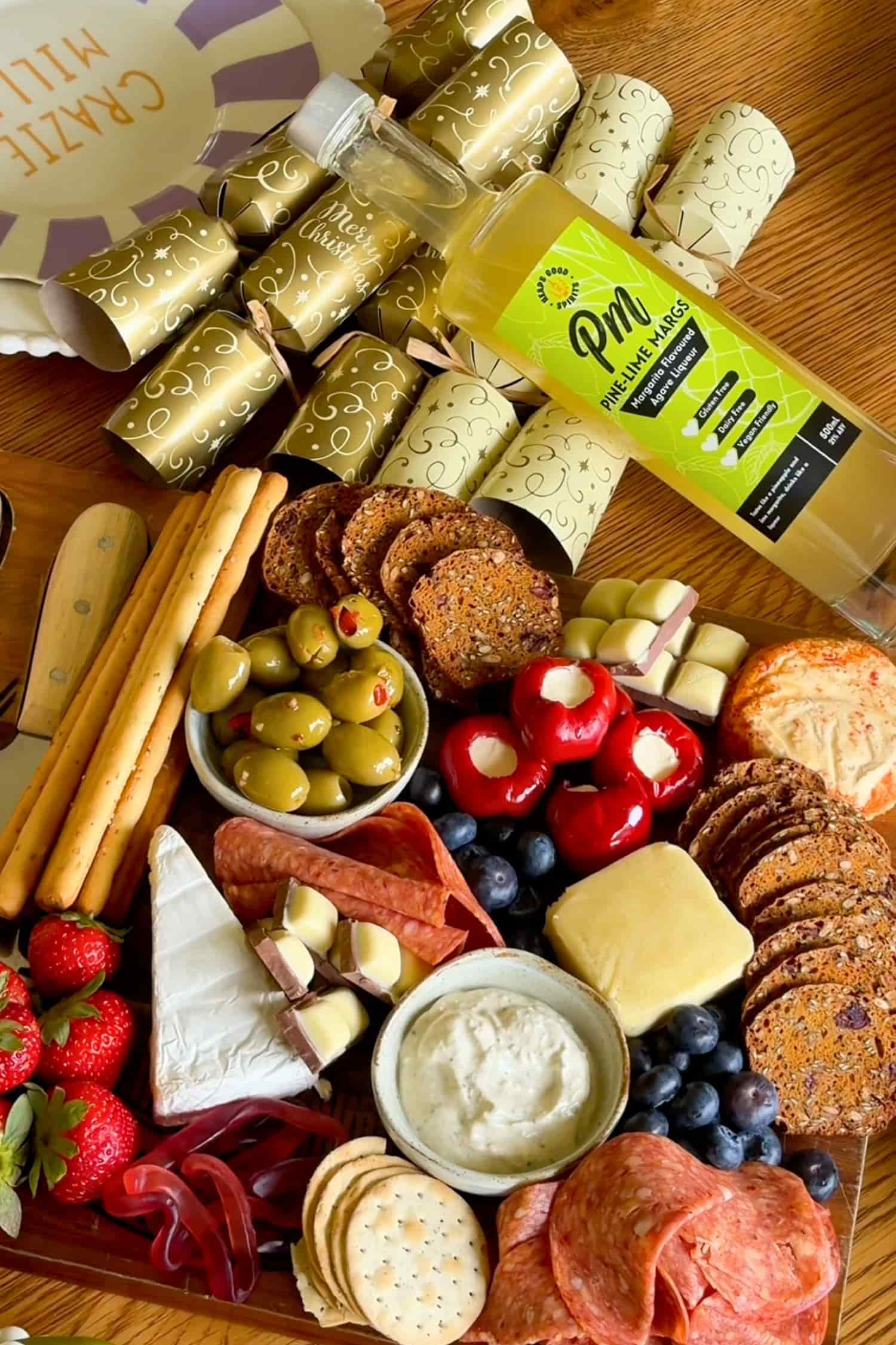 Heaps Good Pine-Lime Margs margarita flavoured agave liqueur bottle styled with festive crackers and charcuterie board