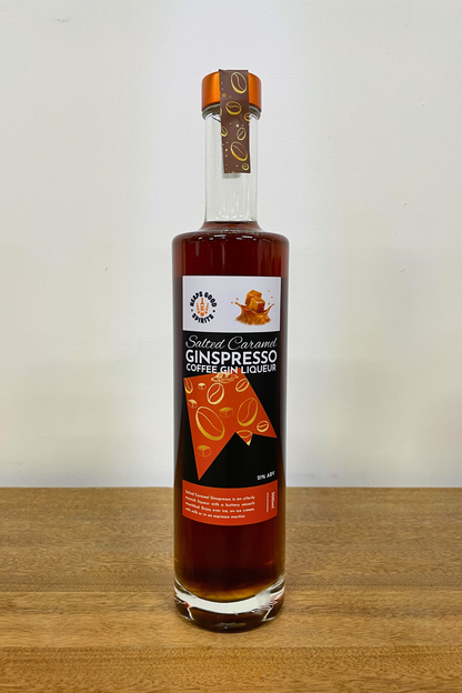 Bottle of Salted Caramel Ginspresso Coffee Gin Liqueur on a wooden surface with a white background
