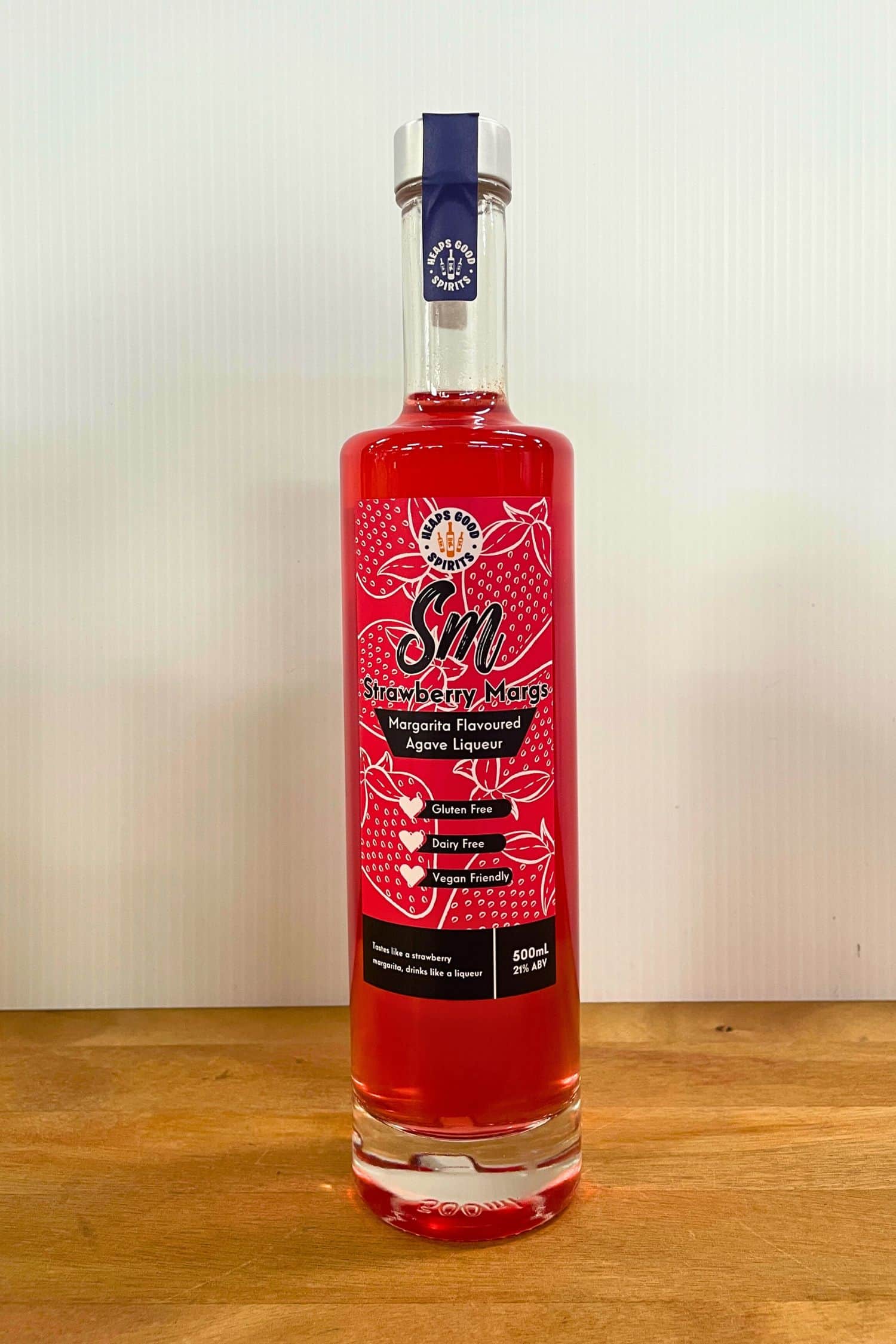 Heaps Good Strawberry Margs 500ml Margarita Flavoured Agave Liqueur bottle on wooden surface against white background