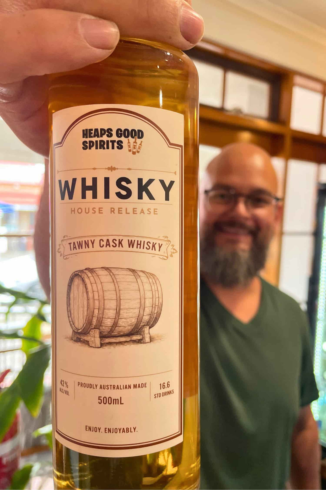 Bottle of Tawny Cask Whisky by Heaps Good Spirits held up by founder Greg.