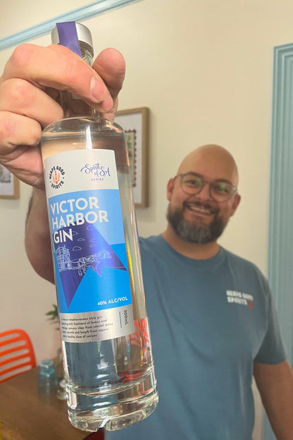 Founder holding Heaps Good Victor Harbor Gin 500ml bottle inside tasting room