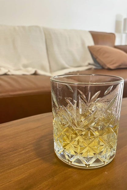 Heaps Good Spirits Whisky on the rocks in a relaxed home setting, with a couch in the background.