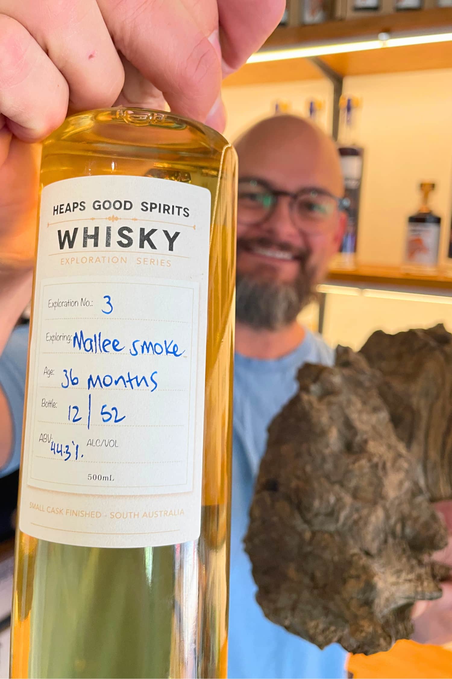 Bottle of Mallee Smoke Whisky held in hand by Heaps Good Spirits founder Greg.