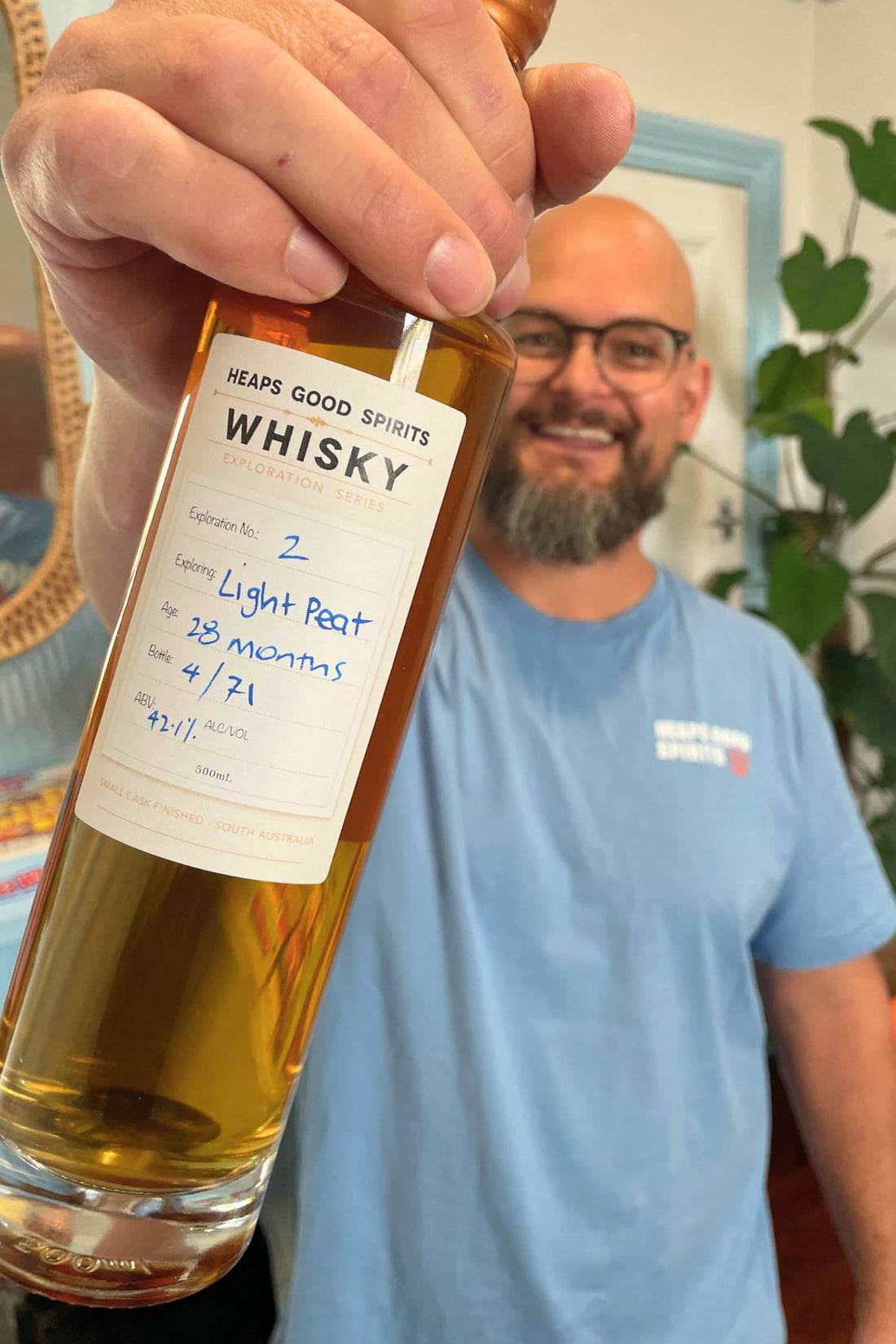 Bottle of Light Peat Whisky held in hand by Heaps Good Spirits founder Greg.