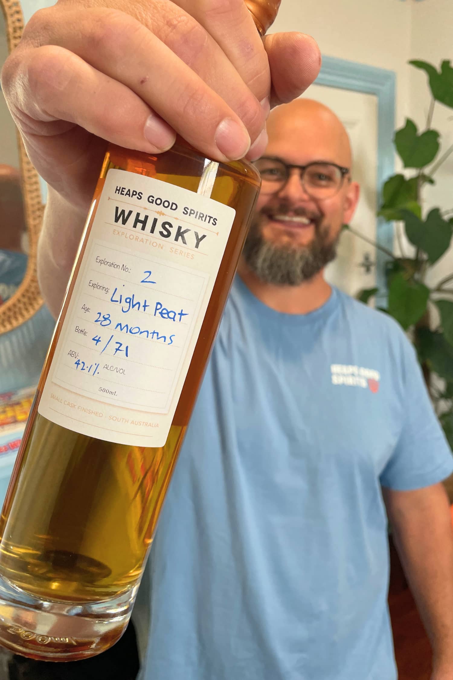 Bottle of Light Peat Whisky held in hand by Heaps Good Spirits founder Greg.